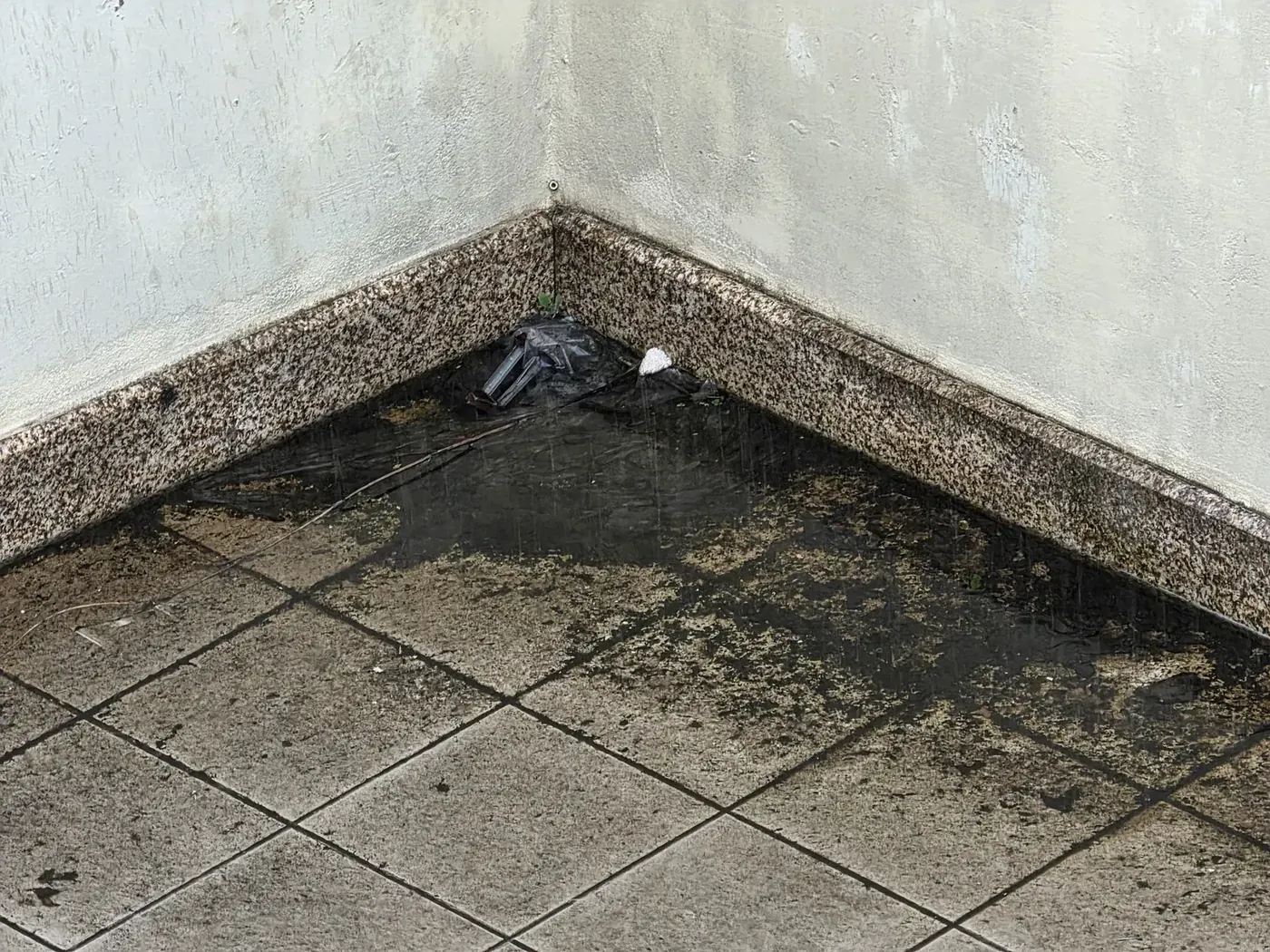 Acumulação de água junto à saída obstruída de um terraço privativo