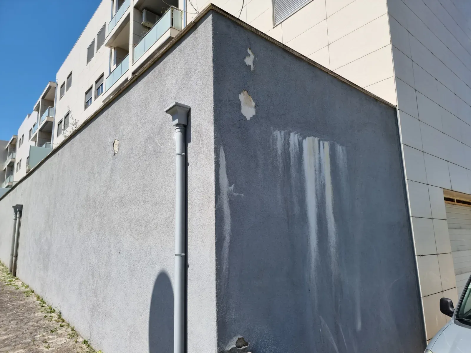 Escorrimentos e degradação na fachada associados à base de murete de terraço