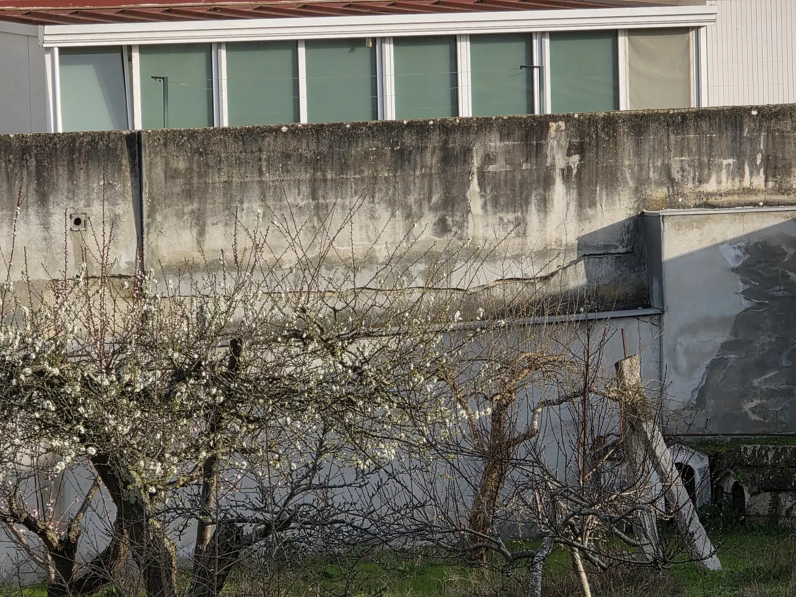 Muro exterior com fissuração e degradação do revestimento